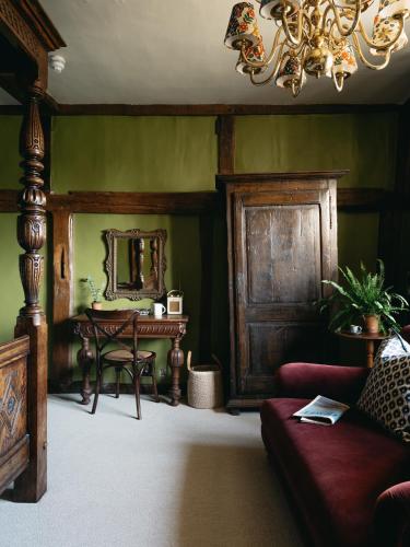 a living room with a table and a mirror at Boys Hall in Willesborough