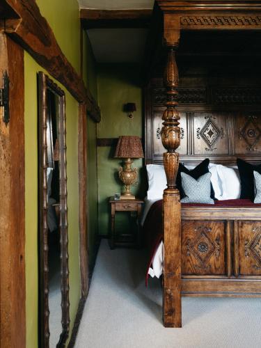 a bedroom with a large wooden bed and a lamp at Boys Hall in Willesborough