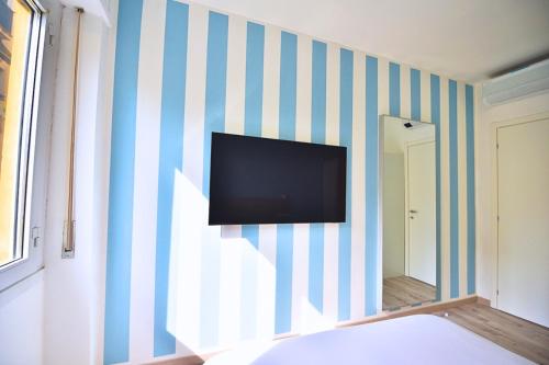 a bedroom with a tv on a striped wall at Tigullio Nest Rapallo in Rapallo