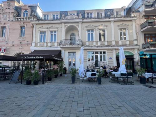 een gebouw met tafels en stoelen op een binnenplaats bij Rooms on Europe Square in Batoemi
