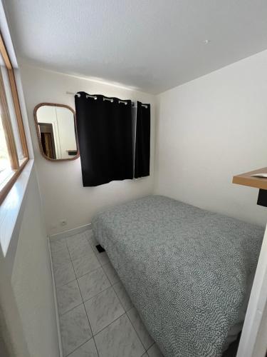 une petite chambre avec un lit et un miroir dans l'établissement 2Pièces, Piscine, Terrasse, à Cagnes-sur-Mer