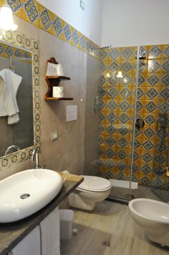 a bathroom with a sink and a toilet and a shower at Al-Tair in San Vito lo Capo