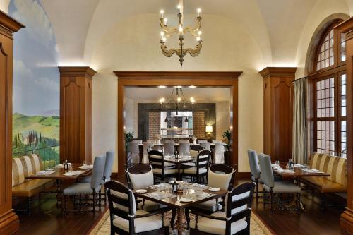 a dining room with tables and chairs and a chandelier at The St. Regis Abu Dhabi in Abu Dhabi