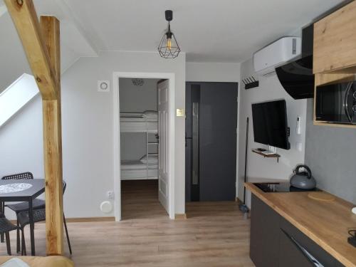 a kitchen and living room with a table and a television at Nowe Apartamenty na Światowida VITO APARTMENTS "centrum"molo 5 min spacerem" in Międzyzdroje