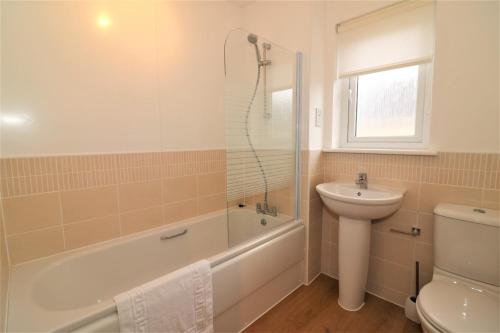 a bathroom with a tub and a sink and a toilet at Signature - Morrison House in Glasgow