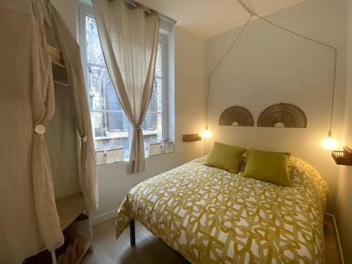 - une chambre avec un lit doté d'oreillers verts et d'un miroir dans l'établissement Polilla - Central et cosy, à Dieppe