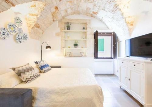 a living room with a bed and a tv at Italianway - Casa Leo in Ostuni