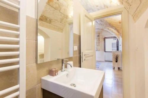 a bathroom with a white sink and a mirror at Italianway - Casa Leo in Ostuni