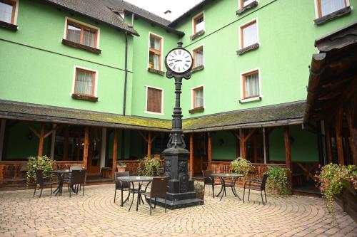 a clock on a pole in front of a building at Mercure Sighisoara Binderbubi Hotel & Spa in Sighişoara