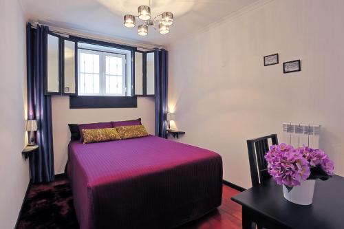 um quarto com uma cama e um vaso de flores em InnLisbon Apartment em Lisboa