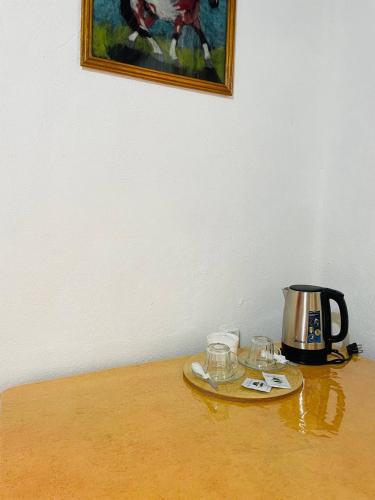 a tea kettle and glasses on a wooden table at Guest house Amirhan in Bokonbayevo