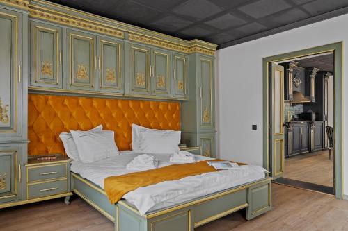 a bedroom with a large bed with an orange headboard at Gela's Terrace Apartment in Sibiu