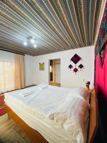 a bedroom with a large bed with a blue ceiling at Guest house Amirhan in Bokonbayevo
