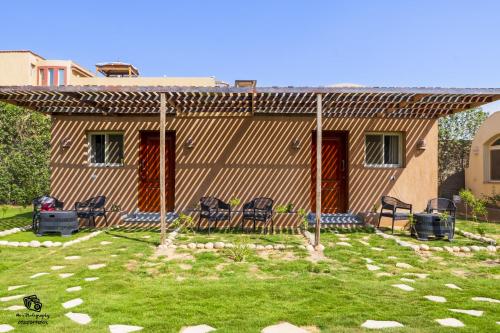 a house with two chairs in a yard at Flower of Life Guest house in Cairo