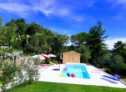 une piscine dans une cour avec une maison dans l'établissement Villa chaleureuse en sud Ardèche avec piscine privée 200 m², à Chassiers