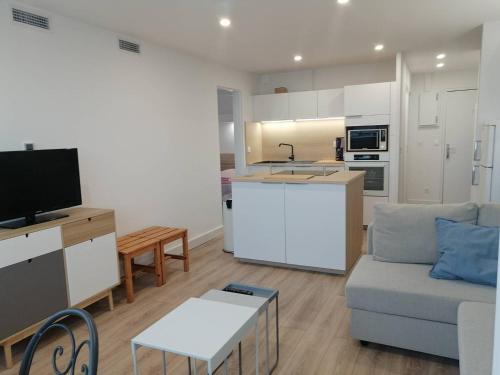 un salon avec un canapé et une cuisine dans l'établissement Coeur de ville Appartement t3 pour 6 personnes N7, à La Grande Motte