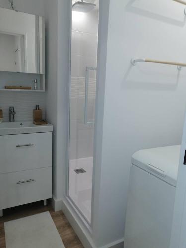 une salle de bain blanche avec une douche et un lavabo dans l'établissement Coeur de ville Appartement t3 pour 6 personnes N7, à La Grande Motte