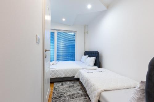 a bedroom with two beds and a window at Evergreen Apartments in Visoko