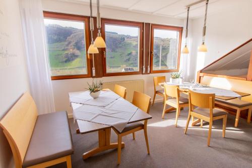 een eetkamer met tafels en stoelen en ramen bij Weingut & Gästehaus Heidhof in Burg (an der Mosel)
