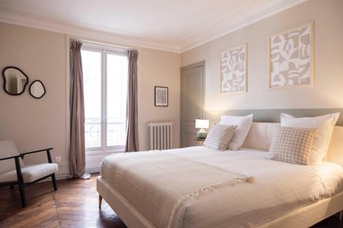 une chambre avec un grand lit blanc et une fenêtre dans l'établissement Chic apartment - 5BR-10P - Grenelle-Eiffel Tower, à Paris
