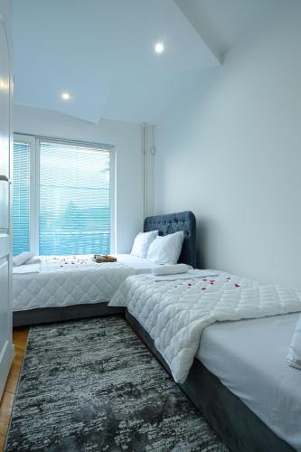 two beds in a bedroom with a window at Evergreen Apartments in Visoko
