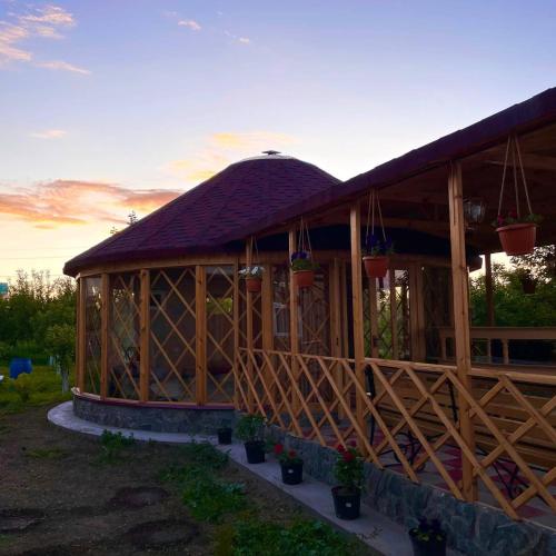 a large wooden building with a gambrel roof at Guest house Amirhan in Bokonbayevo