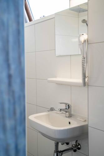 a white bathroom with a sink and a mirror at Het Wapen van Elst in Elst
