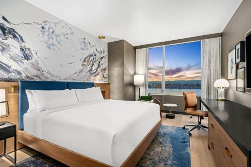 a bedroom with a bed and a desk and a mountain mural at Hotel Indigo Vancouver Dwtn - Portland Area by IHG in Vancouver