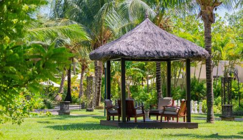 a gazebo with chairs and a straw roof at STORY Seychelles in Beau Vallon