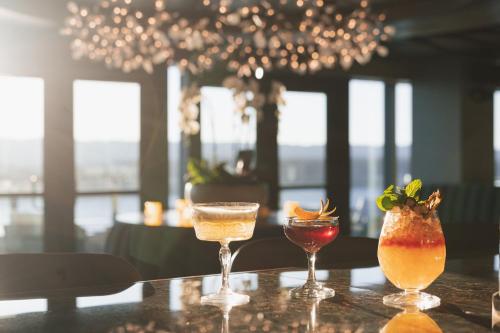 three cocktails on a table in a restaurant at Hotel Indigo Vancouver Dwtn - Portland Area by IHG in Vancouver