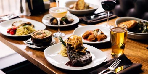 a table with plates of food and glasses of wine at Hotel Indigo Vancouver Dwtn - Portland Area by IHG in Vancouver