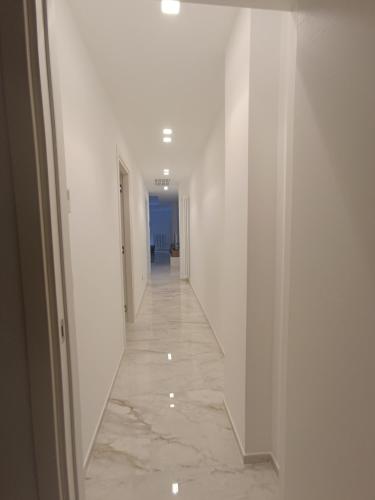 an empty hallway with white walls and a marble floor at Blumoon boutique in Andria