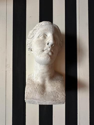 a statue of a head on a wall at AU LIT ON DORT - Logis de Village in Bellême