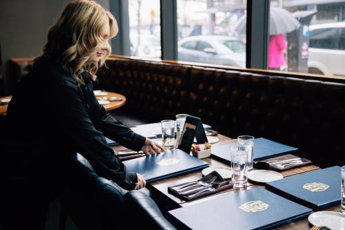 a woman sitting at a table in a restaurant at Hotel Indigo Vancouver Dwtn - Portland Area by IHG in Vancouver