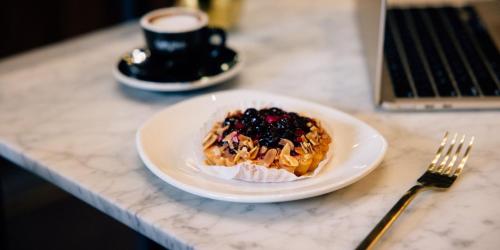 a plate of food on a counter with a cup of coffee at Hotel Indigo Vancouver Dwtn - Portland Area by IHG in Vancouver
