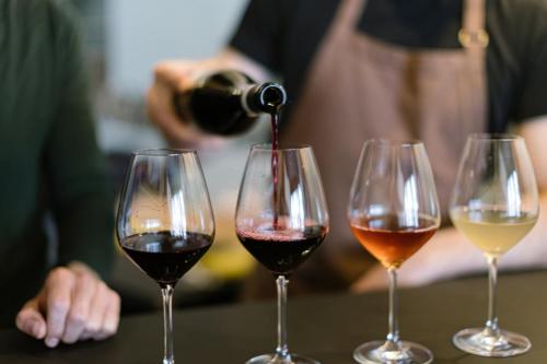a person pouring wine into three wine glasses at Hotel Indigo Vancouver Dwtn - Portland Area by IHG in Vancouver