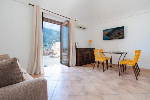 uma sala de estar com mesa e cadeiras em Casa Monticello em Positano