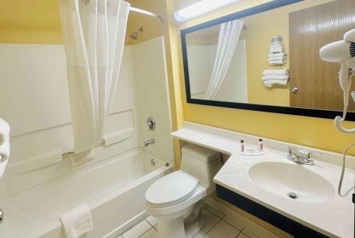 a bathroom with a white toilet and a sink at Super 8 by Wyndham Warrenton in Warrenton