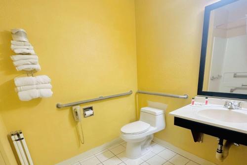 a bathroom with a toilet and a sink at Super 8 by Wyndham Warrenton in Warrenton