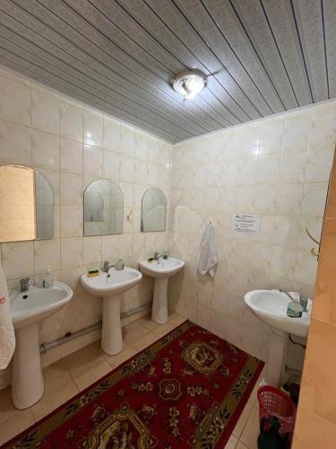 a bathroom with two sinks and two mirrors at Guest house Aidyn-Kul in Toguz-Bulak