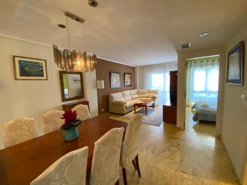 une salle à manger et un salon avec une table et des chaises dans l'établissement Calas de Aguamarina Sea View - Holiday Home Cabo Roig, à Orihuela Costa