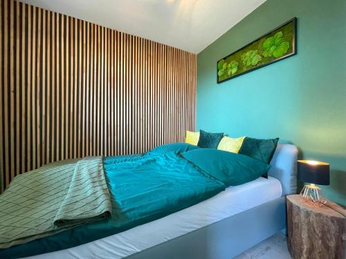 a bedroom with a bed and a wooden wall at LIGHTQUARTIER Mountain Nest -Balkon in Sankt Andreasberg
