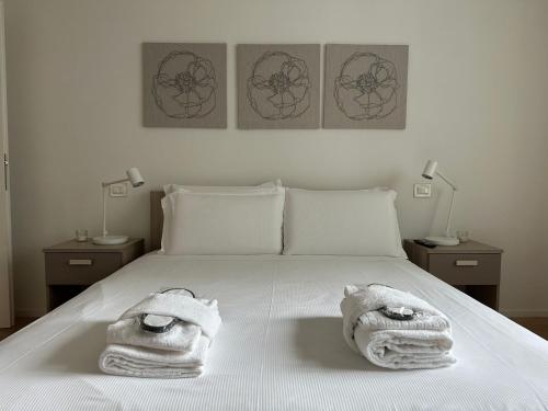 a bedroom with a bed with towels on it at Welc-ōM Padova Santa Sofia in Padova