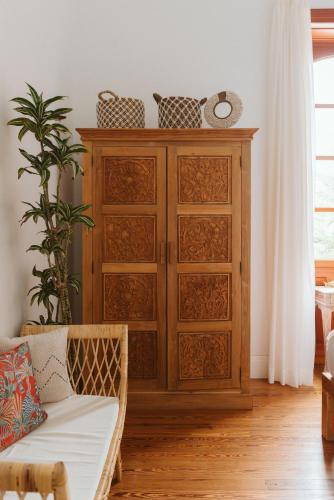 a wooden cabinet in a living room with a couch at Dreamsea Boutique Experience in Moya
