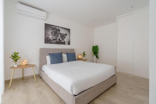 a white bedroom with a large bed and a table at Ammos Villa, beach villa with ocean view in Ribamar