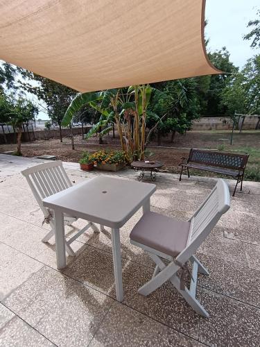 a picnic table and two chairs under a tent at LA CASA DEL NOCE in Ruffano