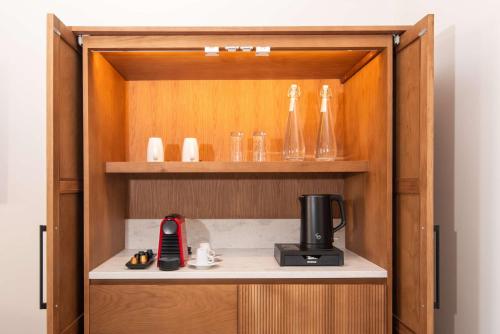 a wooden cabinet with a coffee maker and glasses at Hilton Mauritius Resort & Spa in Flic-en-Flac