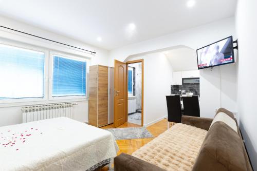 a bedroom with a bed and a tv on a wall at Evergreen Apartments in Visoko