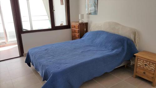 - une chambre avec un lit bleu et une commode en bois dans l'établissement Coeur Plage et commerces Appartement type 3 pour 6 personnes N33, à La Grande Motte