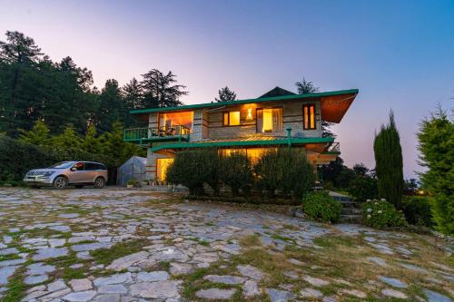 a house with a car parked in front of it at StayVista at The Woods with Indoor Fireplace & BBQ in Chail